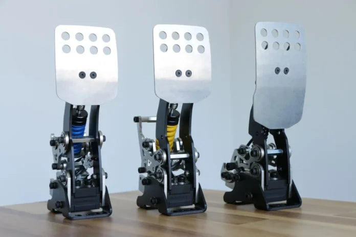 Les trois pédales du pédalier de sim racing Simgrade VX-PRO alignées sur une table